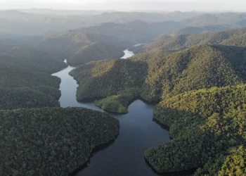 Foto tirada por um drone, de um rio serpenteando entre morros