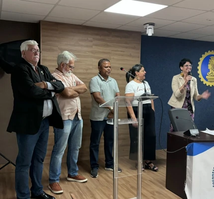 Foto de palestrantes de pé no palco