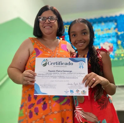 Aluna e professora exibindo certificado de participação