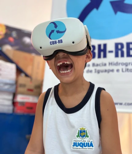 Foto de um menino alegre, com um óculos de realidade virtual.